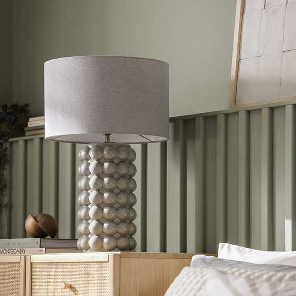 Grey bobble lamp on a bedside table.